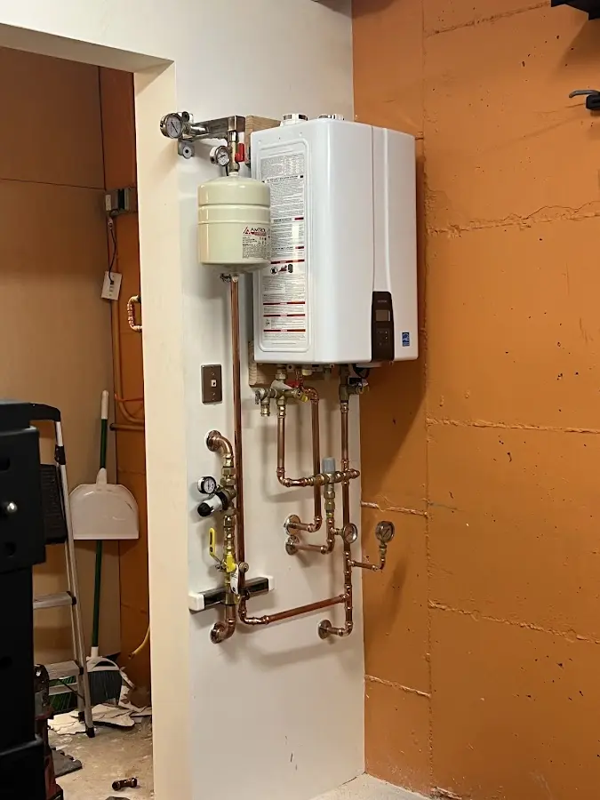 Plumbing technician inspecting water heater connections in Yazoo City